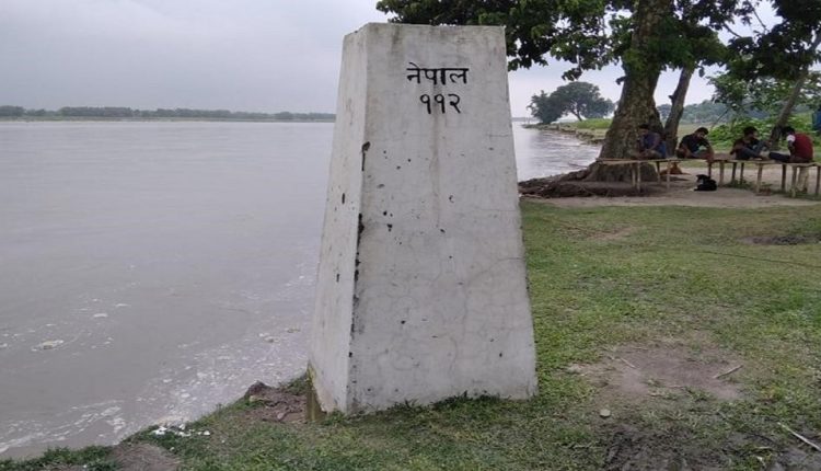 भारत-नेपाल सीमा पर नदी की आगोश में समाने को तैयार इंटरनेशनल बॉर्डर पिलर।